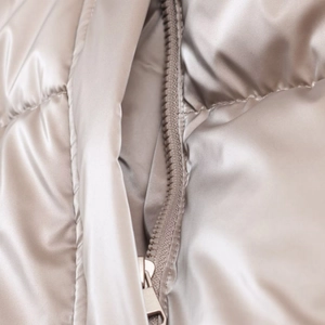 Detail of champagne quilted puffer jacket featuring smooth satin fabric and a zipper closure