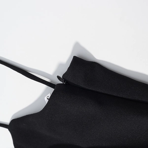 Detail of black polka dot dress showing fine straps, side zipper, and size S label