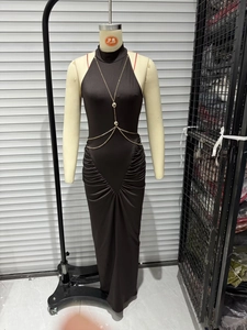 Detail of black halter maxi dress featuring ruching and gold chain body accessory