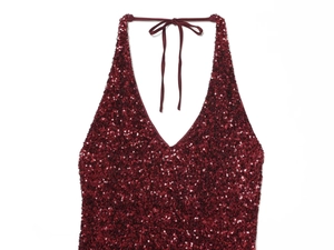 Close-up of sparkling burgundy sequins on halter neck dress with detailed stitching