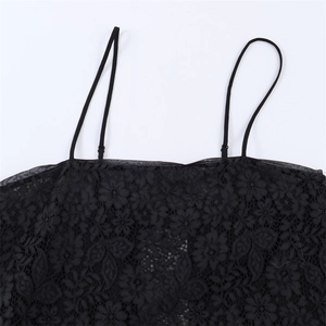 Détail de la texture en dentelle florale noire et des fines bretelles du haut caraco