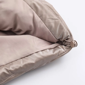 Detail of glossy quilted fabric with adjustable drawstring and toggle on a winter coat