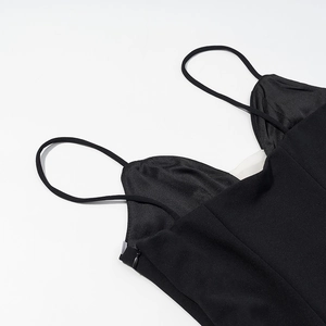 Detail view of slim spaghetti straps and V-neckline on a sexy black polka dot dress