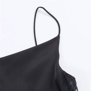 Detail of elegant black satin dress with delicate lace trim and thin spaghetti strap