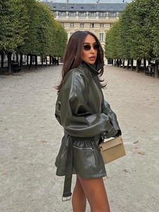 Detailed macro view of olive green PU leather jacket with waist belt and silver zipper pocket