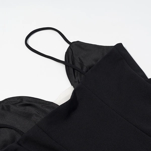 Close-up of thin spaghetti straps and deep V-neckline on a black polka dot dress