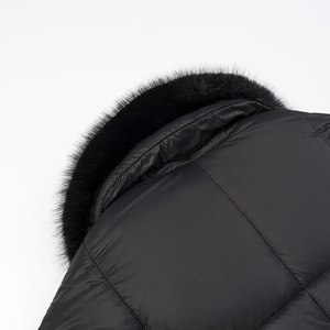Detailweergave van dikke zwarte gewatteerde jas met afneembare kraag van imitatiebont en stiksels