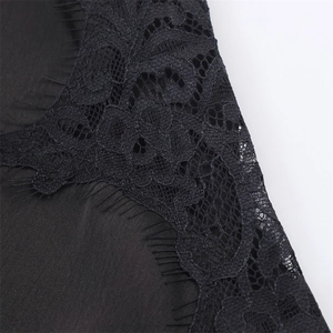 Detailed close-up of delicate black eyelash lace trim on smooth satin dress fabric