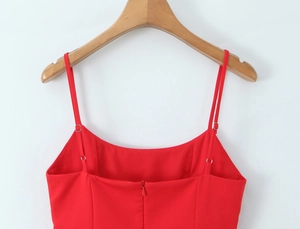 Detail of red camisole top featuring thin adjustable straps and a hidden back zipper