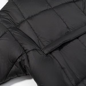 Detail van de gewatteerde zwarte winterjas met zijzak en winddichte stoftextuur op maat