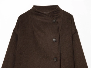 Close-up of dark brown wool coat with textured fabric and classic button closure detail