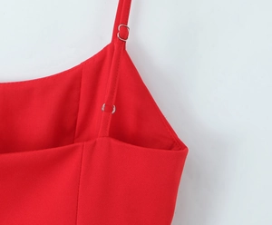 Detailed close-up of adjustable thin red straps with silver metal buckles on a dress