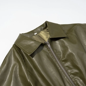 Close-up of olive green faux leather jacket lapel featuring metallic silver zipper detail