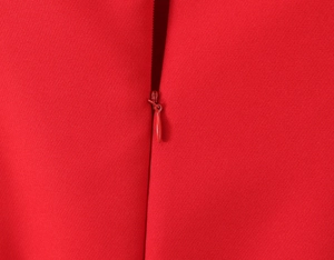 Macro view of seamless matching red invisible zipper on woven fabric of the dress