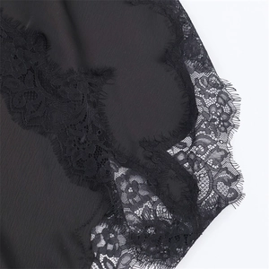 Macro shot of delicate black eyelash lace trim and embroidery detail on dress
