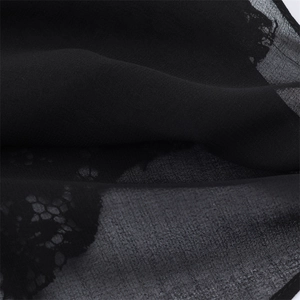Gros plan sur le tissu noir transparent avec dentelle florale pour un haut sexy chic