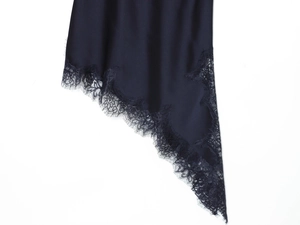 Detailed view of the navy satin hem with delicate eyelash lace and asymmetric cut