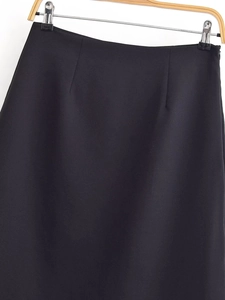 Detailansicht eines schwarzen High-Waist-Midirocks mit präziser Schneiderarbeit und Stoff