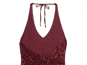 Detail of burgundy sequin fabric on halter dress showing texture and drawstring neck tie