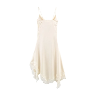 Detail of champagne satin slip dress featuring delicate lace trim and asymmetrical hem