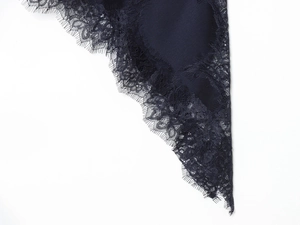 Detail shot of delicate eyelash lace trim and premium fabric on a dark evening dress