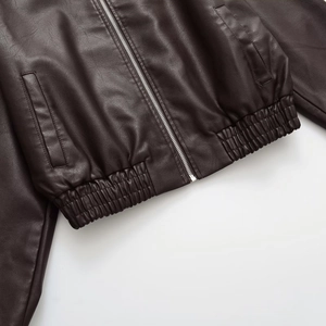 Detailed macro view of dark brown PU jacket with silver zipper and elastic pleated hemline