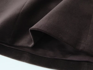Detail of dark brown velvet fabric showing heavy drape and neat stitching craftsmanship