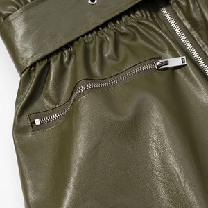 Detail of army green faux leather jacket with elastic waist, metal eyelets and silver zipper