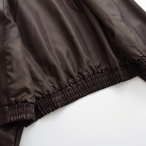 Detail of dark brown leather jacket showing satin lining and elastic hem construction