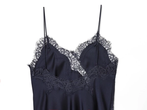 Detail of dark blue satin camisole featuring delicate black lace trim at the neckline