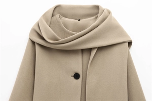 Detail of wool blend coat collar featuring a unique scarf-style neck and black button