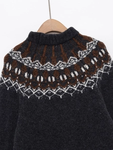 Detail of grey Fair Isle knit sweater showing wool texture and Nordic pattern