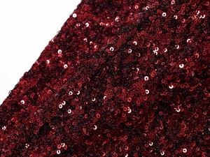 Macro shot of burgundy sequin fabric detailing the texture for evening dress