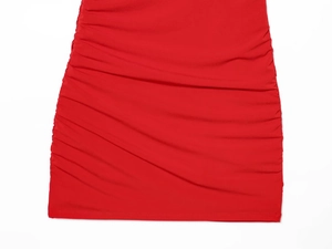Détail de la robe froncée rouge montrant le tissu élastique et les coutures latérales