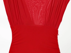 Détail d'une robe en résille rouge avec textures plissées et fermeture éclair latérale