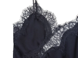 Close-up of black satin camisole top featuring delicate eyelash lace trim and V-neckline detail