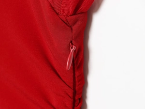 Détail d'une robe rouge avec patchwork en mesh et fermeture éclair invisible fluide
