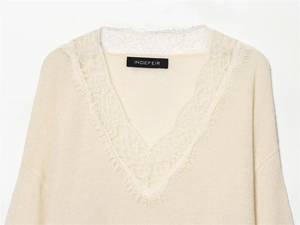 Detail of elegant V-neckline with delicate lace trim on beige knitted sweater