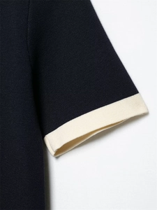 Detail of short sleeves on knitted cardigan showing contrast ribbed cuffs and navy blue texture