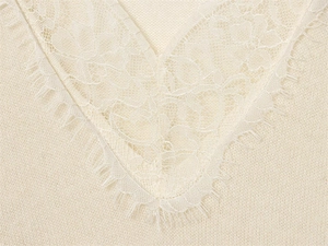Detail of cream V-neck knit sweater featuring delicate eyelash lace trim and soft fabric