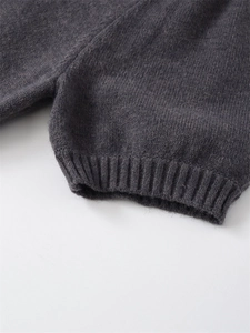 Close-up detail of dark grey ribbed knit cuffs showing fine stitching and soft wool texture