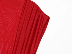 Détail du patchwork en maille rouge et de la texture plissée d'une mini-robe tendance