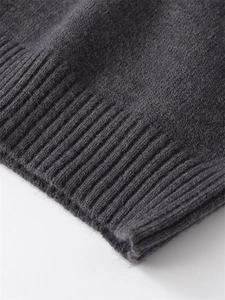 Close-up of charcoal gray ribbed cuffs on a loose-fit knit sweater with soft texture