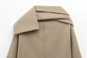 Detailed view of camel wool blend coat neckline with layered lapel and premium stitching