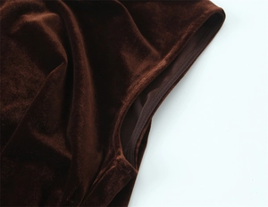 Close-up of deep brown velvet fabric texture and stitching detail on a mini dress