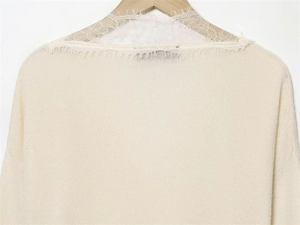 Detail of elegant cream knit sweater featuring delicate white lace collar stitching