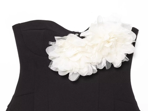 Gros plan détaillé des fleurs en tissu 3D blanches sur un haut bustier noir élégant