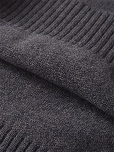 Detailed macro view of dark grey knit texture with soft fibers and ribbed cuff finish