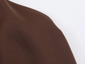 Close-up detail showing the diagonal twill texture of the dark brown satin fabric