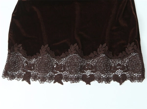 Close-up of coffee brown velvet hem with intricate floral lace embroidery detail
